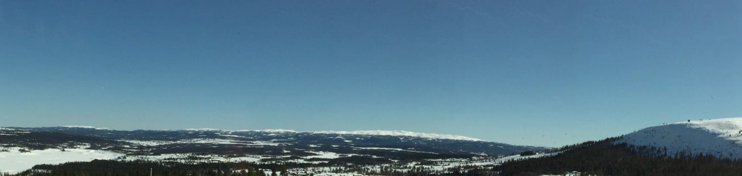 Snow-covered mountainous Norwegian terrain with forests and valleys