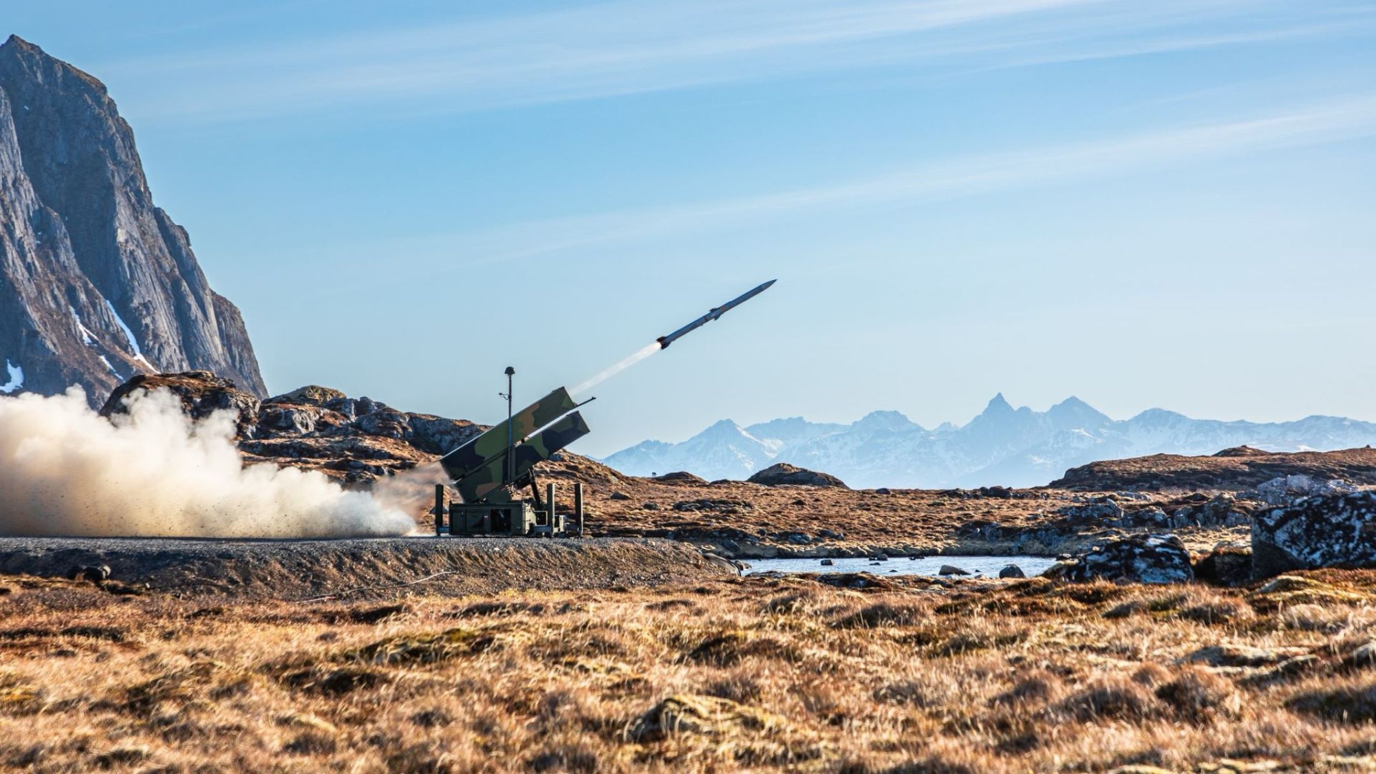 Luftvernlauncher avfyrer med snødekte fjell i bakgrunnen