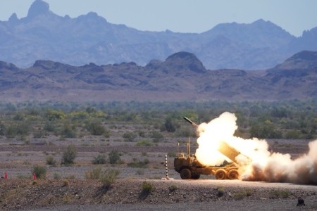 Patriot air defense system firing at twilight in coastal Nordic terrain