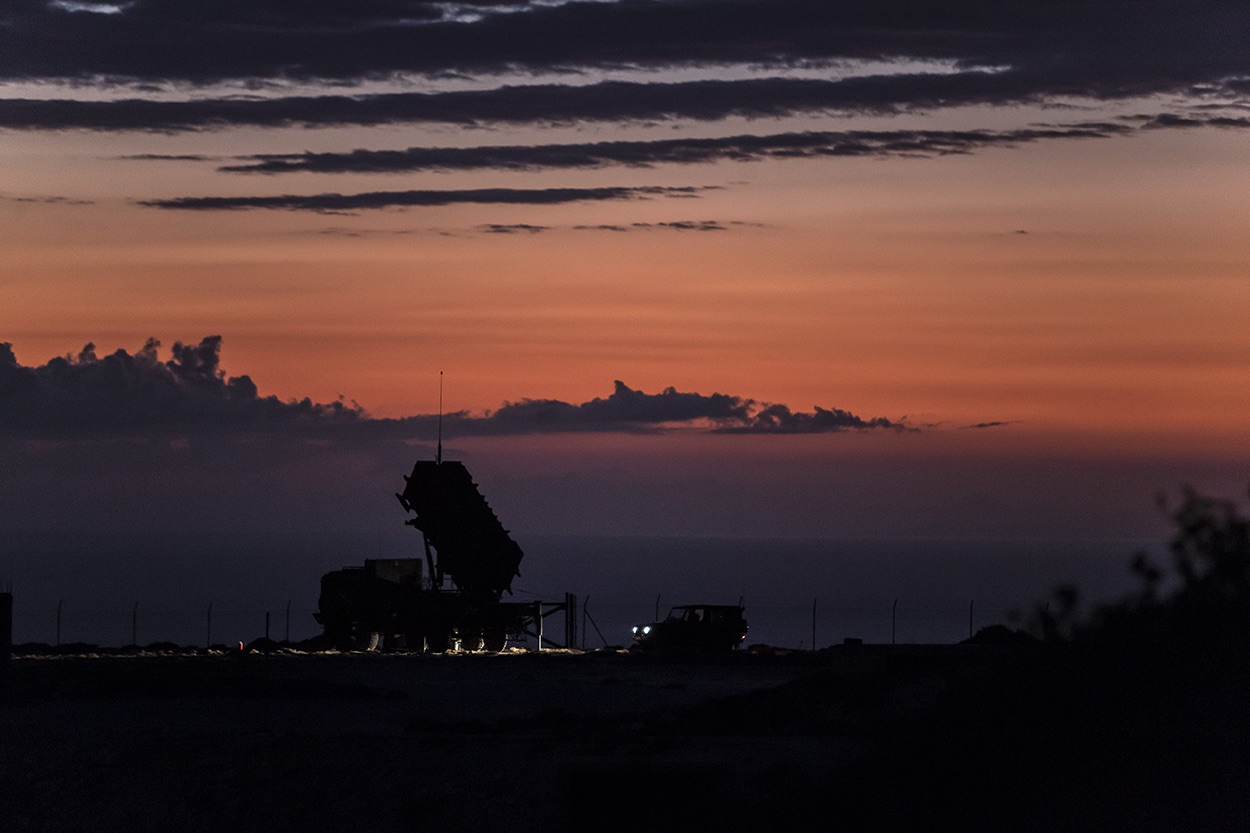 Patriot air defense system radar and launcher silhouetted at dusk
