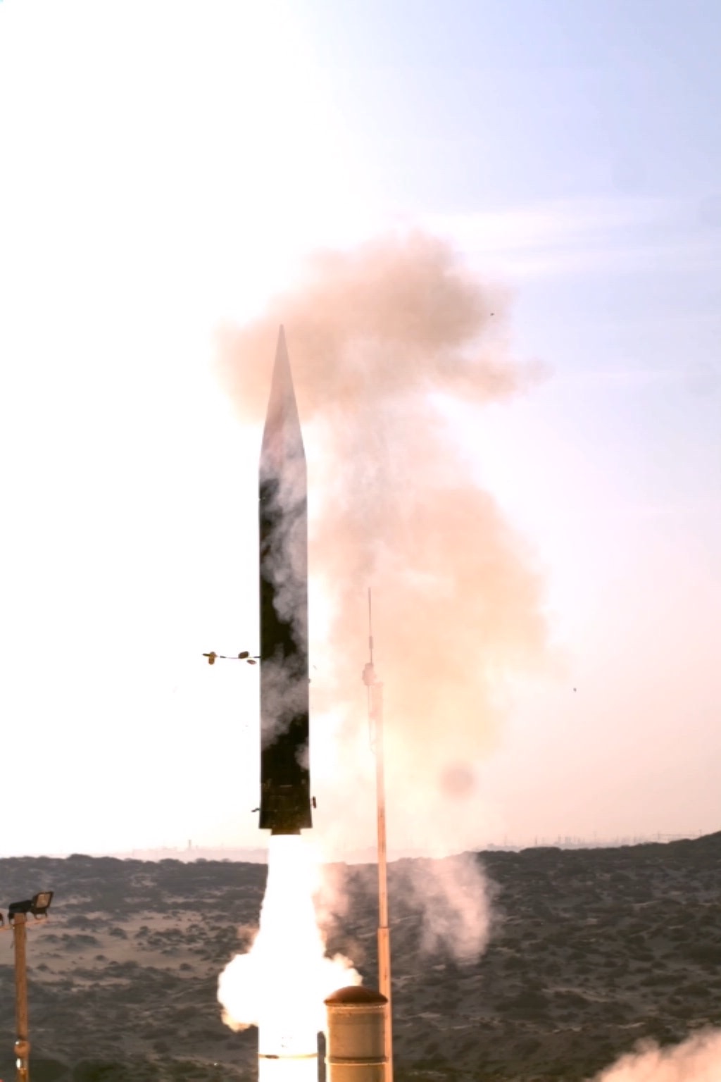 Ballistic missile launch from the ground with aircraft in the background